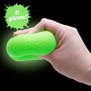 Hand holding a green glowing squshy toy with 'It glows!' text on a black background