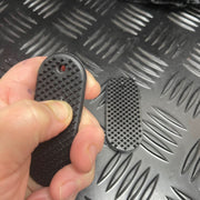 Hand squeezing firm PVC Kaiko SpiKEYring pad for focused sensory pressure