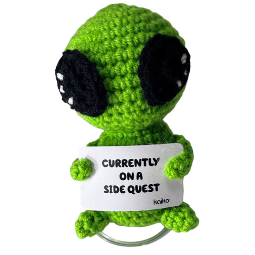 Front-facing Currently on a Side Quest green alien crochet critter with message