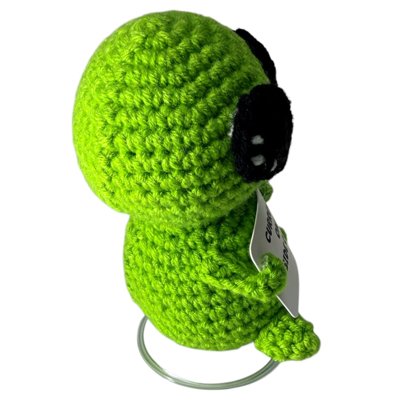 Side view of Currently on a Side Quest green alien crochet critter