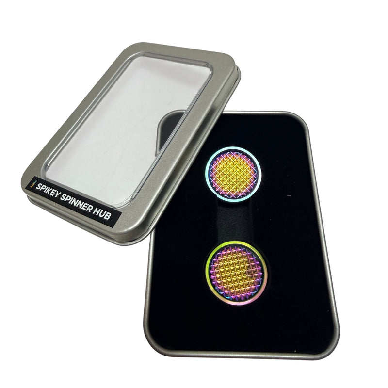 Pair of oil slick Spikey Spinner Hubs displayed in the included window tin